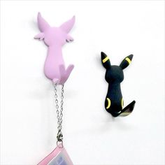 two keychains with different designs on them, one is pink and the other is black