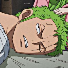 a man with green hair laying on top of a bed next to another person in pink shirt