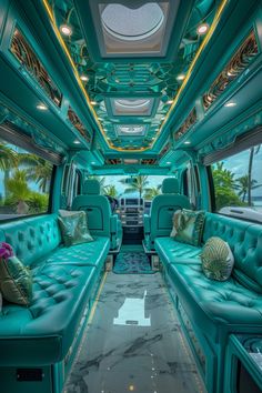 the interior of a bus with blue leather couches and green walls, palm trees in the background