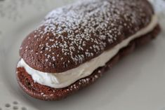 a chocolate sandwich with cream filling on a white plate