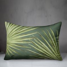 a green pillow with palm leaves on it