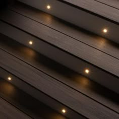 some lights that are on the side of a wooden building in the dark night time