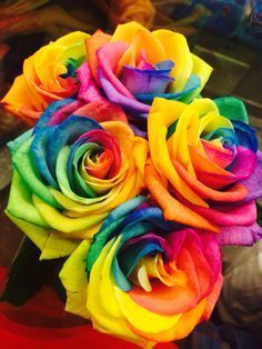 a bouquet of multicolored roses sitting on top of a table