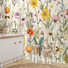 a bathroom with flowers painted on the wall and two stools in front of it