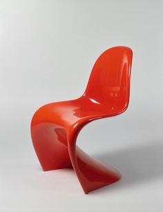 an orange chair sitting on top of a white floor