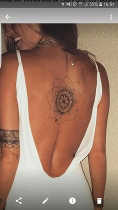 the back of a woman's white top with tattoos on her shoulder and chest