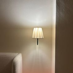 a room with a couch and lamp on the wall