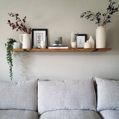 a living room filled with lots of furniture and flowers on top of a wooden shelf