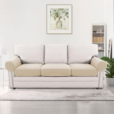 a living room with a white couch and potted plant