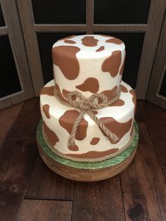 a three tiered cake with brown and white designs