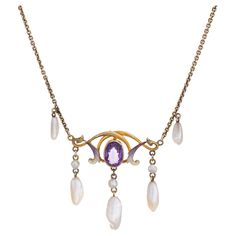 Stylish and finely detailed Art Nouveau drop necklace (circa 1900s to 1910s) crafted in 14 karat yellow gold. One estimated .75 carat amethyst, 6mm x 3.5mm to 9mm x 3mm sawtooth pearls and enamel are set into the necklace. The amethyst is in very good condition and free of cracks or chips. Note: slight chip to enamel. The beautifully made Art Nouveau necklace highlights the faceted center set oval amethyst with accenting purple and white enamel. Natural pearls are set in a fringe style to the ba Gold And Enamel Jewelry, Antique White Gold Necklace, Art Nouveau Jewelry Vintage, Antique Pearl Necklace, Stile Art, Festoon Necklace, Art Nouveau Necklaces, Detailed Art, Fringe Fashion