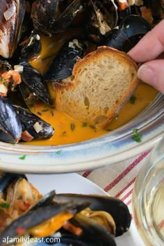 a bowl filled with mussels and sauce on top of a table