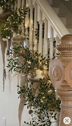 christmas decorations on the banisters and stairs in a home decorated with greenery