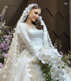 a woman in a white wedding gown and veil