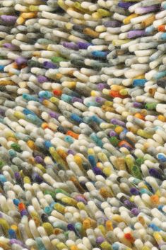 an area rug with multicolored circles and dots on the carpet is shown in close up