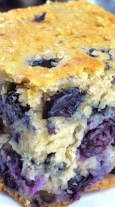 a close up of a piece of cake with blueberries on it's crust