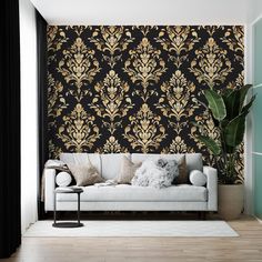 a white couch sitting in front of a black and gold wallpapered living room