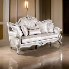 a white couch sitting in a living room on top of a hard wood floor next to a wall