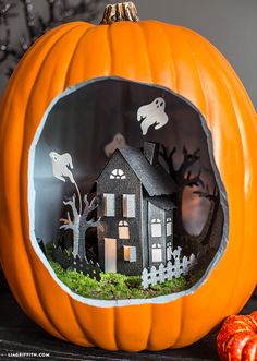 a pumpkin with a house in the window