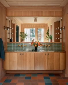 a bathroom with wooden cabinets and tile flooring in front of a large mirror on the wall