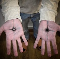 two hands with small black stars on them