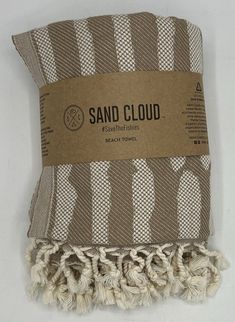 two white and brown striped towels on top of each other with a cardboard tag hanging from it