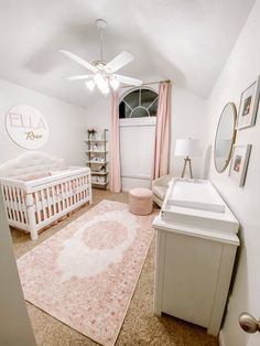 a baby's room with a pink rug and white crib