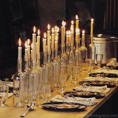 a long table with candles and plates on it