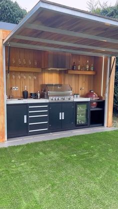 an outdoor kitchen is built into the side of a shed with lots of storage space