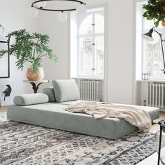 a living room with a large couch and potted plants