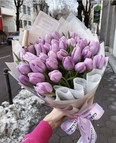 a person holding a bouquet of purple tulips