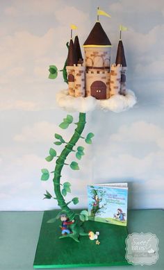 a cake with a castle on top of it and a book in the foreground