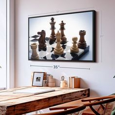 a wooden table sitting in front of a window next to a painting on the wall