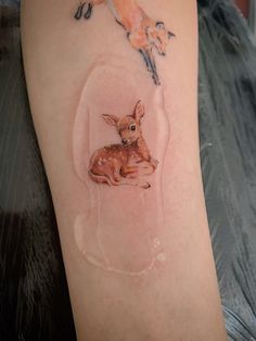 a small deer tattoo on the right arm and leg, with an image of a baby deer