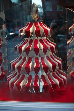 a red and white striped christmas tree in a store window