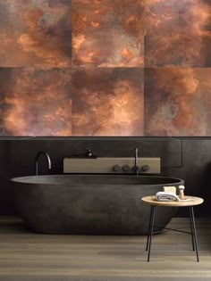 a bath tub sitting next to a wall covered in brown and orange paint on it