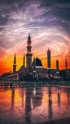 a large building with a clock tower on it's side at sunset or dawn