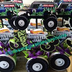 monster trucks are stacked on top of each other with purple and green ribbons around them