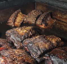 steaks are cooking in an outdoor grill