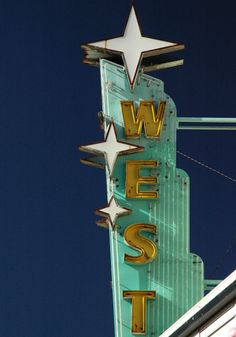 an old neon sign that says west with stars on it