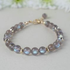 This exquisite handmade bracelet showcases AAA-grade Labradorite gemstones with stunning iridescence, accented by shiny 14K gold-filled saucer beads and clasp. It is made with premium 49-strand stringing wire, ensuring durability and lasting quality. Finished with a 1-inch long extension chain for the perfect fit. Believed to enhance intuition and inner strength, this labradorite bracelet offers both captivating beauty and meaningful energy, perfect for any jewellery lover's collection. ⧫  S I Z Seed Beaded Bracelets, Stone Bracelets, Labradorite Bracelet, Women Jewellery, Natural Stone Bracelets, Beads Handmade, Jewellery Gift, Bracelet Ideas, Handmade Bracelet