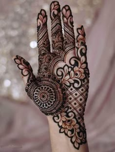 a woman's hand is decorated with hennap and intricate designs on it