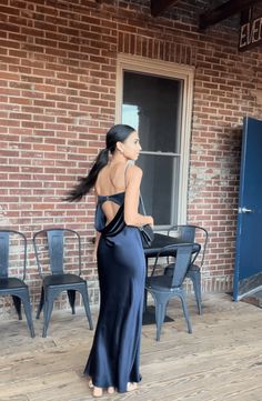 a woman standing in front of a brick building