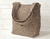 a brown and white tote bag sitting on top of a wooden table next to a wall