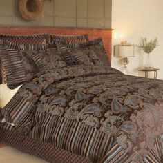 a bed with a brown and blue comforter on top of it