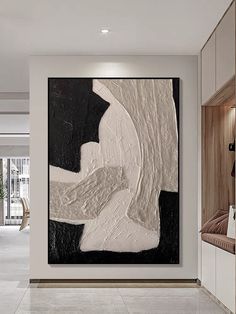 an abstract painting hangs on the wall next to a white and black chair in a modern living room