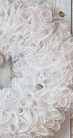 a white lace wreath hanging on a wooden door