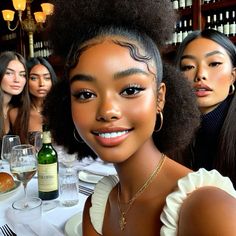 three beautiful women sitting at a table with wine glasses and bottles in front of them