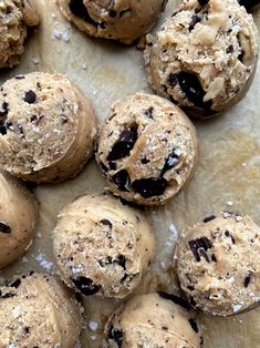 chocolate chip cookies on parchment paper with sprinkles and sea salt scattered around them