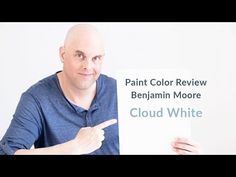 a man holding up a sign that says paint color review sherylin williams shoji white